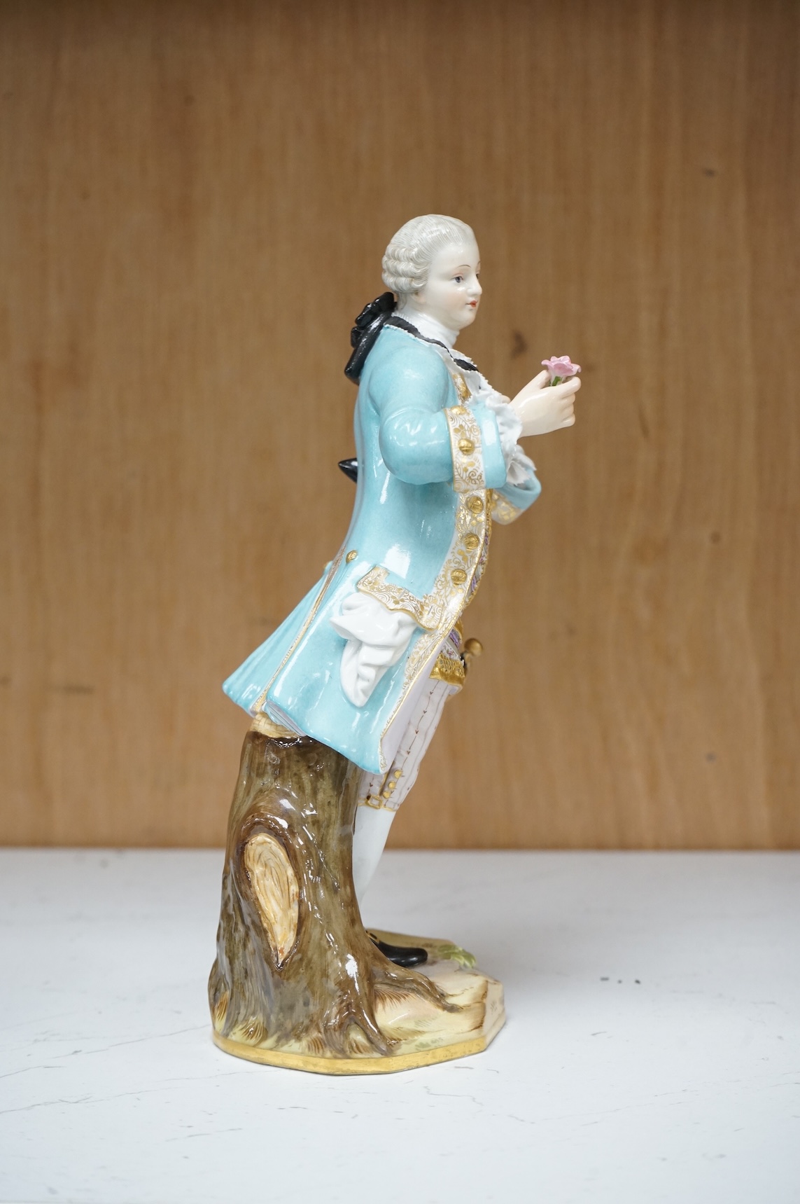 A Meissen figure of a gentleman holding a rose, 19th century, incised model number A58, 19cm high